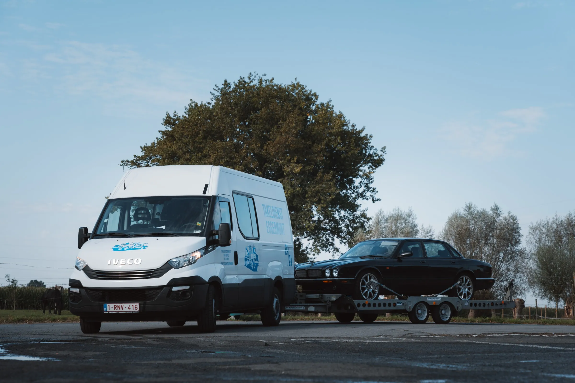 De bestelwagen met aanhangwagen schuin van voren