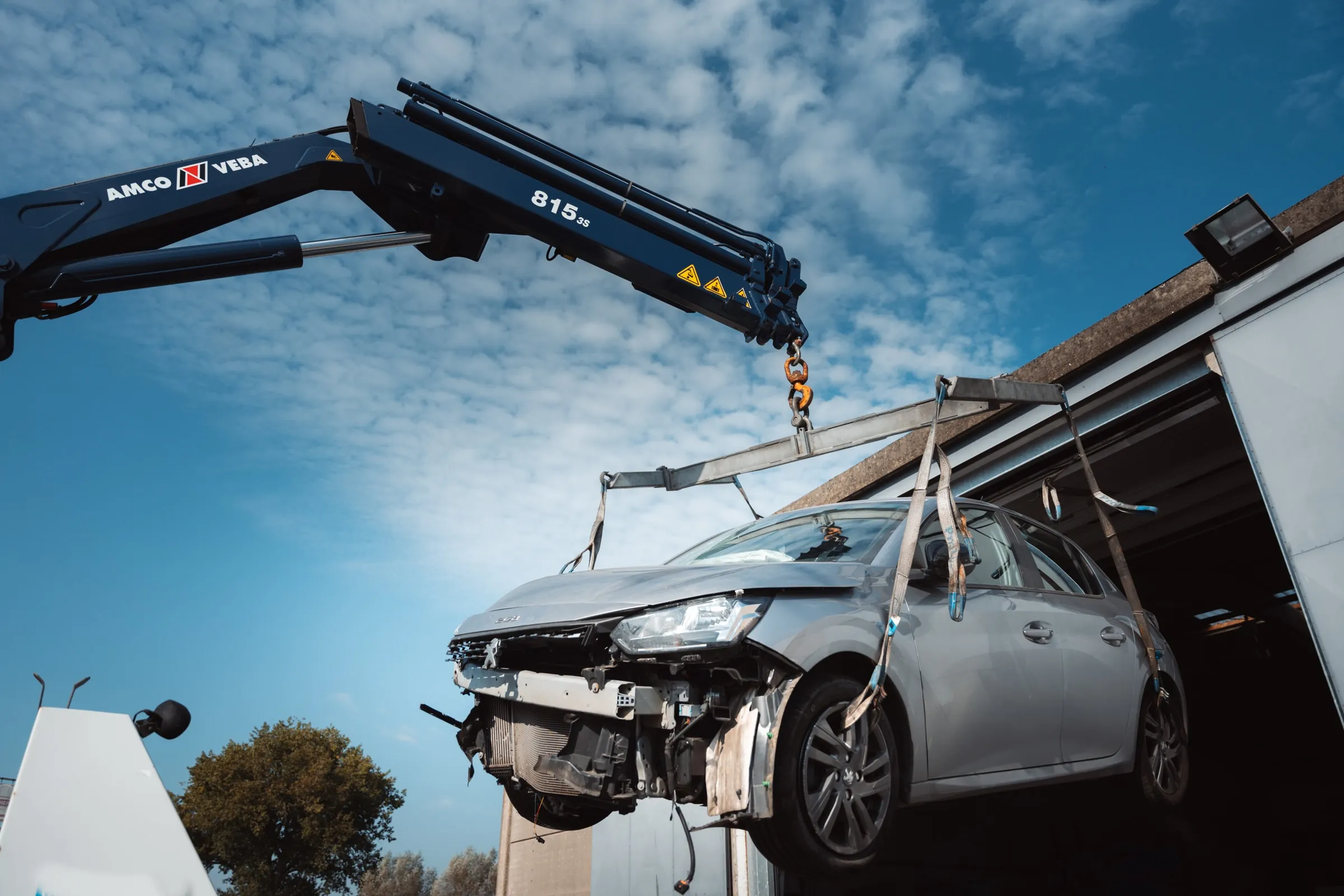 De kraan van Eggermont tilt een beschadigde wagen van de grond