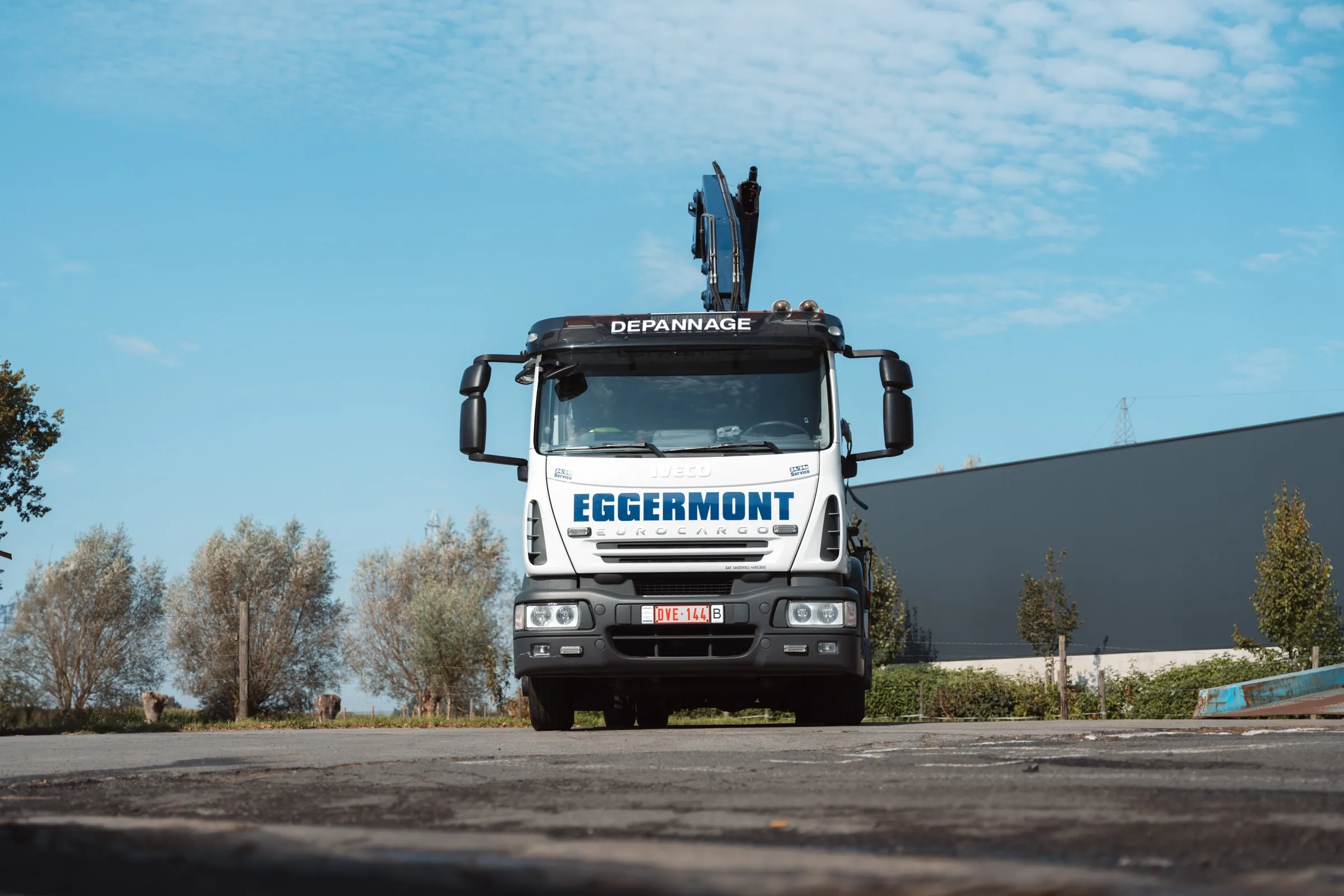 De kraanwagen recht van voren, met de kraan omhoog