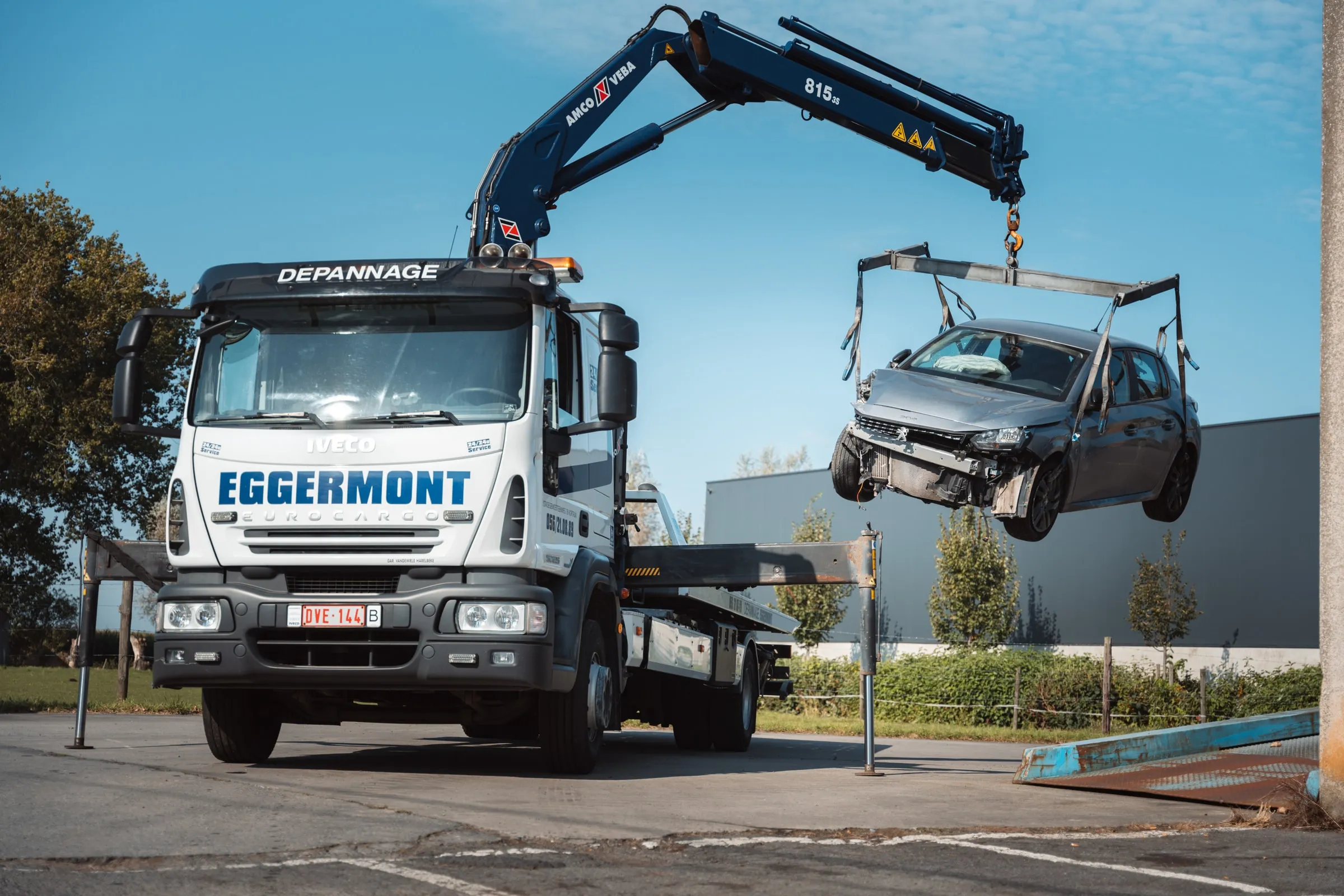 De kraanwagen zet een wagen op het plateau