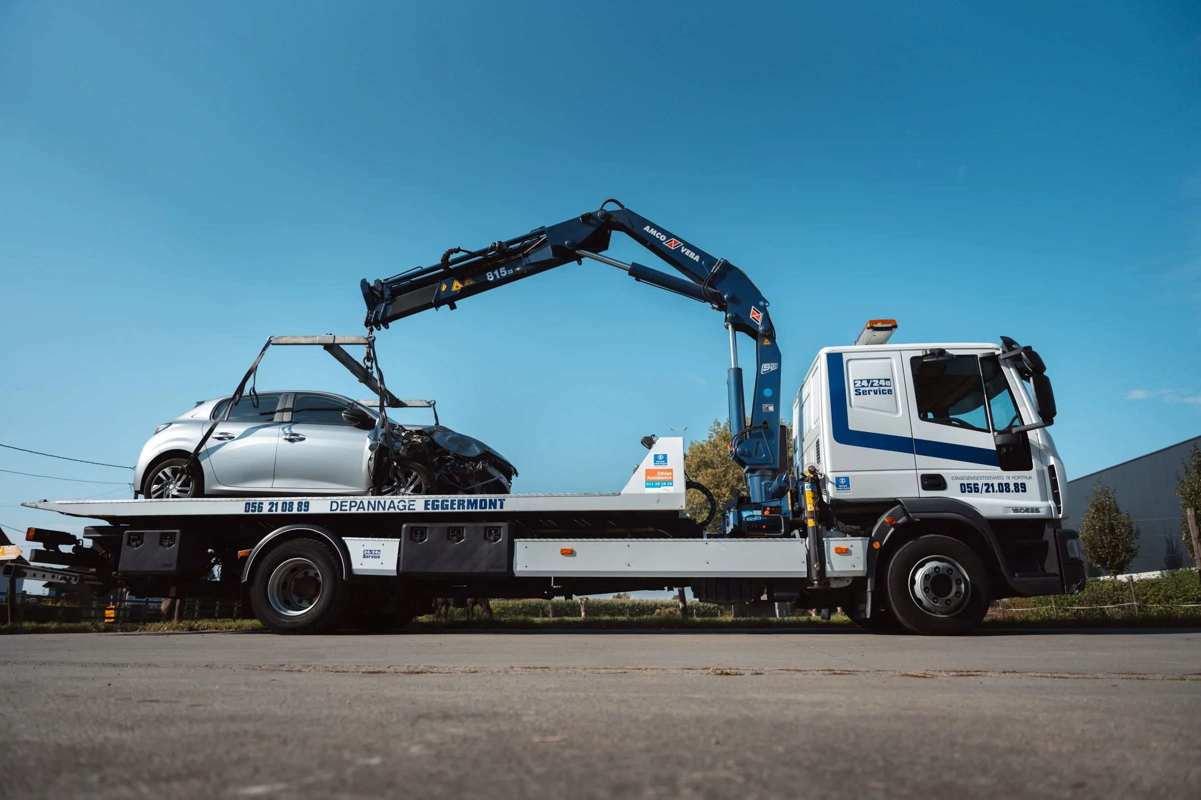 De kraanwagen van Eggermont van opzij, met een beschadigde wagen op het plateau